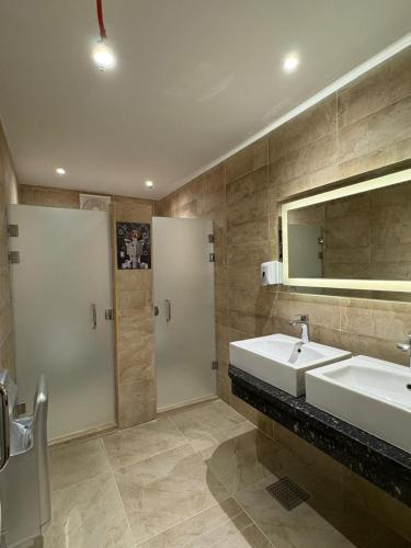 a bathroom with two sinks and a shower and a mirror at The Fit Stop Hostel in Hurghada