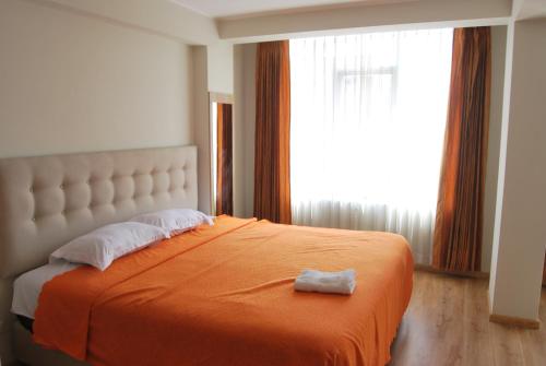 a bedroom with a large bed with an orange blanket at Kymeron Hotel in Juliaca