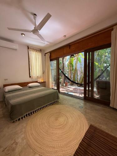 a bedroom with a large bed and a large window at la baxada mazunte in Mazunte