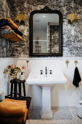 a bathroom with a sink and a mirror at Ebony & Ivory Villa in Nelson Bay