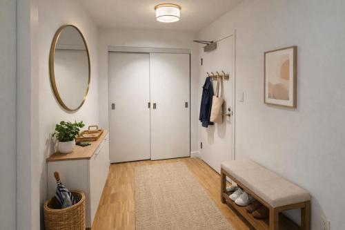 a hallway with a door and a stool and a mirror at Pacific Pearl in Vancouver