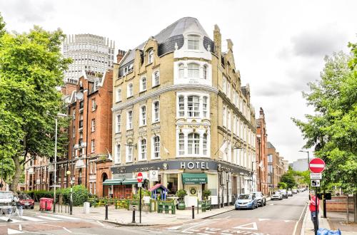 a large building on a city street with cars parked at City London Hotel in London