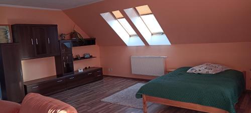 a bedroom with a green bed and two skylights at ELEKTRa in Stare Bielice