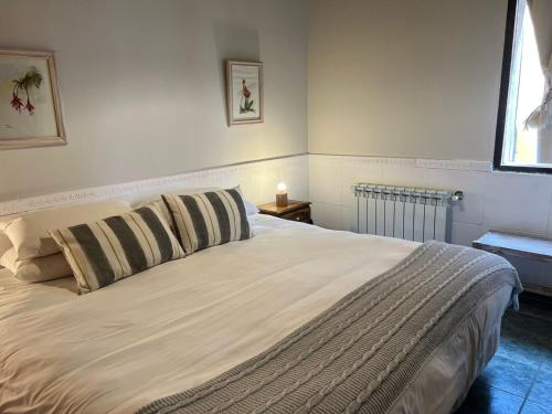 a bedroom with a large white bed with two pillows at Casa Viedma in El Chalten