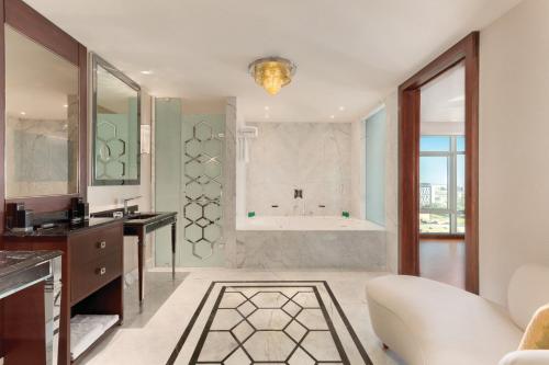 een badkamer met een bad en een wastafel en een badkamer bij Wyndham Grand Istanbul Europe in Istanbul