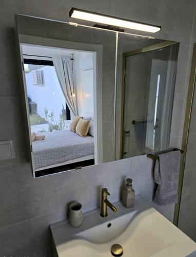 a bathroom with a sink and a mirror with a bed at Atlantic Dreams II in Pico da Pedra