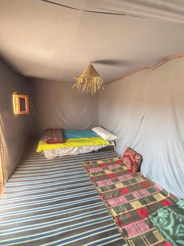 a small room with two beds in a tent at Bivouac Porte du Désert in Mhamid