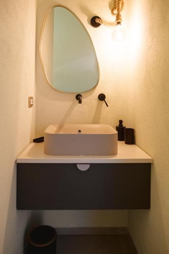 a bathroom with a white sink and a mirror at Casa Dante in Putignano