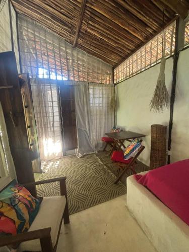 a room with a bed and a table in a room at REFUGIO do SAGRADO MORERE Tropical Lodge - A CASA das BRUXAS in Moreré