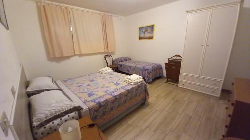 a small bedroom with two beds and a dresser at L'Alba della Tavernetta in Locorotondo