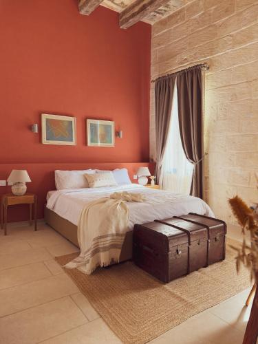 a bedroom with red walls and a bed with a suitcase at Nelsonhaus -Boutique Guesthouse in Cospicua