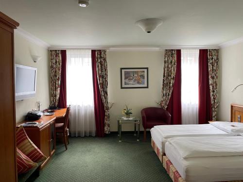 a hotel room with a bed and a desk at Hotel Ochsen Stuttgart in Stuttgart