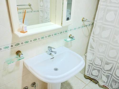 a bathroom with a sink and a mirror at Casa Encanto in Mar de las Pampas