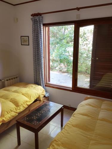 a bedroom with two beds and a large window at Casa Encanto in Mar de las Pampas