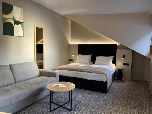 a hotel room with a bed and a couch at Hotel NOVA Inn Sarajevo in Sarajevo