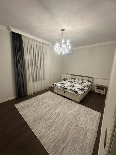 a bedroom with a bed and a chandelier at Villa Mardakan in Mərdəkan