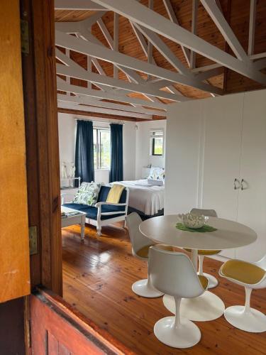 a living room with a bed and a table and chairs at Sunny studio in the sky in Brenton-on-Sea