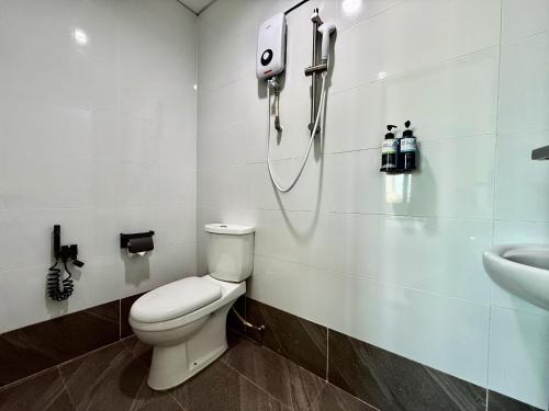 a bathroom with a toilet and a sink at Serene Turtle Hotel in Kuala Terengganu