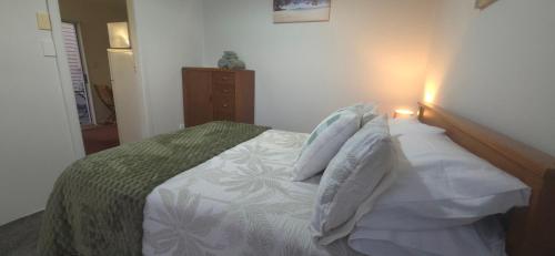 a bedroom with a bed with a wooden headboard at Cozy corner on Cohen in Nelson