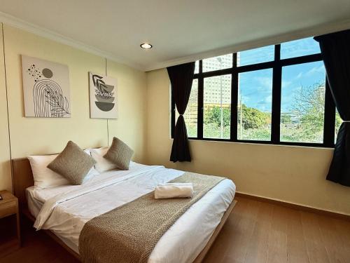 a bedroom with a bed and a large window at Serene Turtle Hotel in Kuala Terengganu