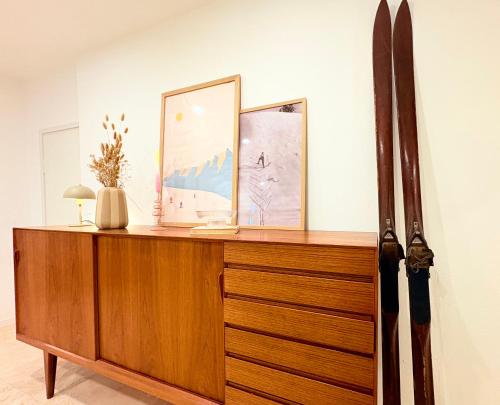 a wooden dresser with two pictures and a knife at Zentrale Wohnung in Garmisch mit Zugspitzblick in Garmisch-Partenkirchen