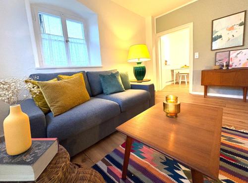 a living room with a blue couch and a table at Zentrale Wohnung in Garmisch mit Zugspitzblick in Garmisch-Partenkirchen