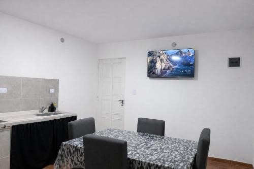 a kitchen with a table and a sink and a picture on the wall at Departamentos Turísticos Cloe 2 in Fiambalá
