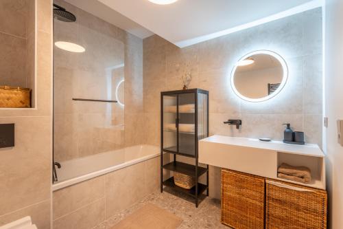 a bathroom with a sink and a tub and a mirror at Monaco Bliss apartments 5 min to Casino in Beausoleil