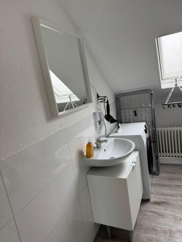 a white bathroom with a sink and a mirror at Monteurwohnung Krefeld WorkStay in Krefeld