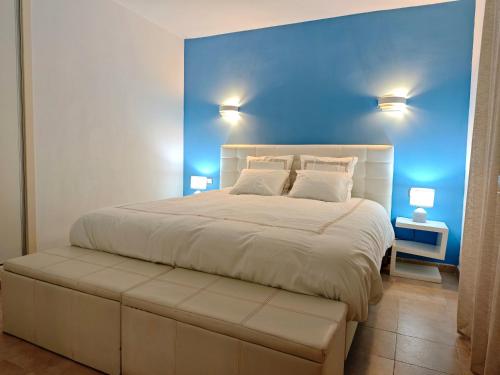 a bedroom with a large bed with a blue wall at Canyamel Beach in Canyamel