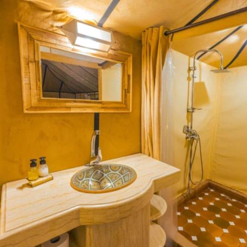 a bathroom with a sink in a tiny house at Sand Dunes Luxury Camp in Merzouga