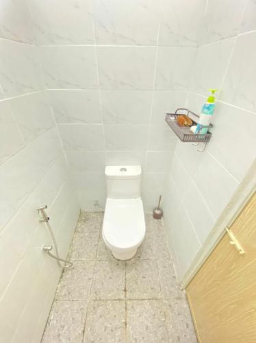 a bathroom with a toilet with a basket on the wall at AL Homestay Pendang in Pendang