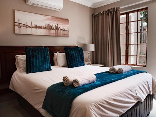 a bedroom with a large bed with towels on it at The Orion Guesthouse in Middelburg