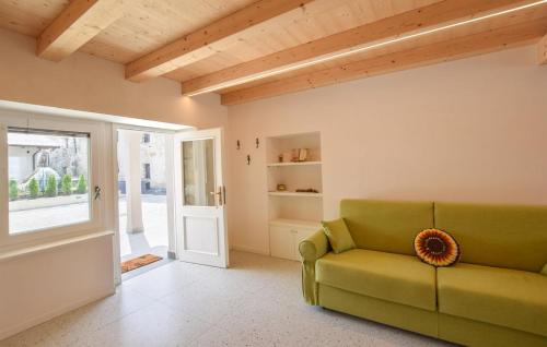a living room with a green couch and an open door at Corte Maccarini - Appartamento Venezia - Dotato di corte interna privata in Mel