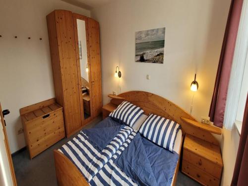 a bedroom with a bed with two striped pillows at Ferienanlage Orther Reede, Fehmarn-Orth in Orth