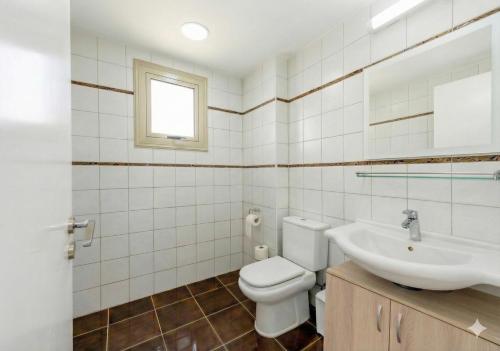 a bathroom with a toilet and a sink at Fig Tree Beach Villa Five in Protaras