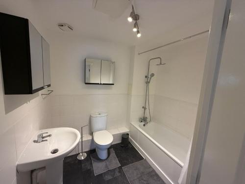 a bathroom with a toilet and a sink and a tub at Modern flat in Abbey Wood in Abbey Wood