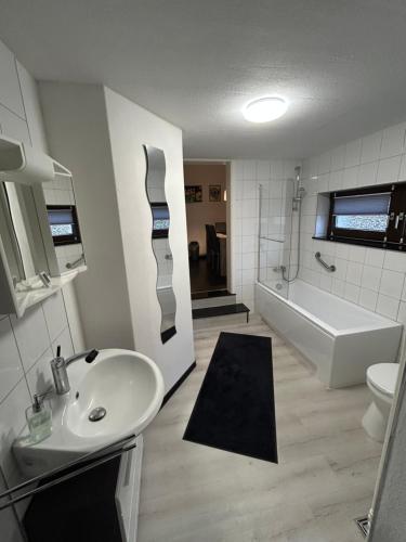 a bathroom with a sink and a bath tub at Ferienwohnung Sofie Marie in Oberhausen