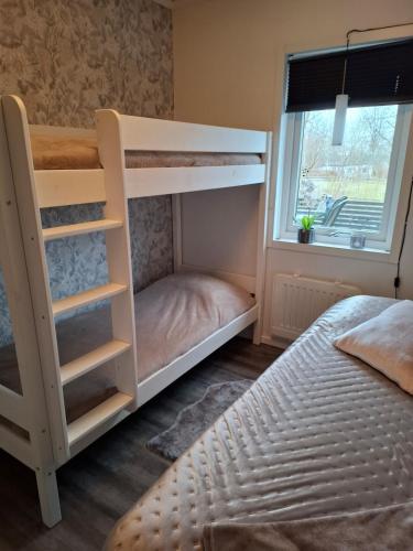 a bedroom with two bunk beds and a window at Charmig stuga med havsutsikt in Karlskrona