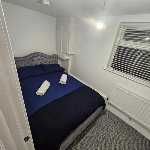 a bedroom with a blue bed and a window at Snug on Eden Derry in Londonderry County Borough