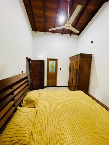 a bedroom with a large bed and a ceiling fan at Dream villa in Imaduwa