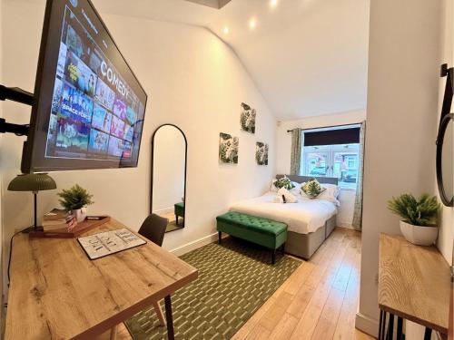 a bedroom with a bed and a tv and a table at Private All-Weather Hot Tub House, Fire Pit, Free Parking, Near City Centre, Freeman Hospital, Great Transport Links in Longbenton