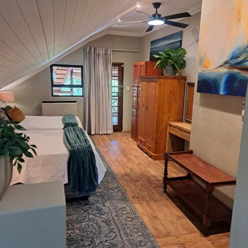 a bedroom with a bed and a bench in a room at Kruger Tree Lodge in Marloth Park