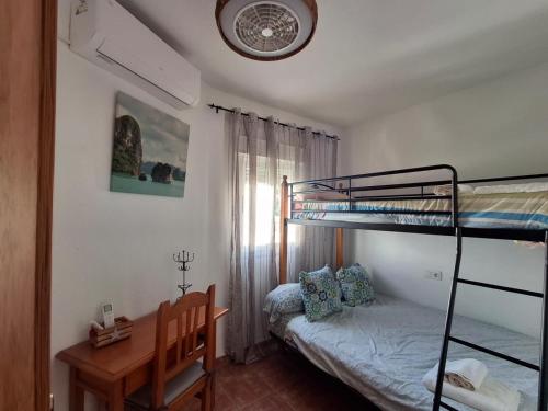 a small bedroom with a bunk bed and a desk at Duplex Barbados Aguamarga in Agua Amarga