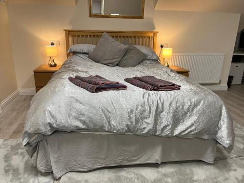 a bed with two towels on it with two lamps at Quiet studio flat near University & QMC, King size bed in Nottingham