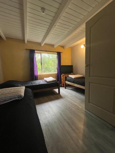 a room with two beds and a window at El Kamaruco Hostel in El Chalten