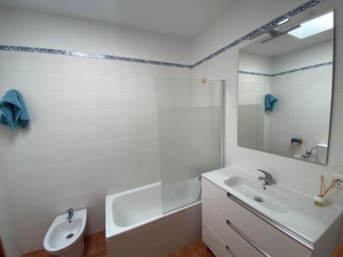 a white bathroom with a sink and a mirror at Duplex Barbados Aguamarga in Agua Amarga