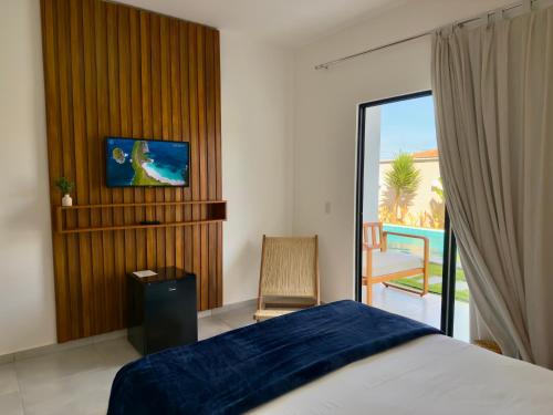 a bedroom with a bed and a view of a patio at Yahweh Hotel in São Miguel do Gostoso