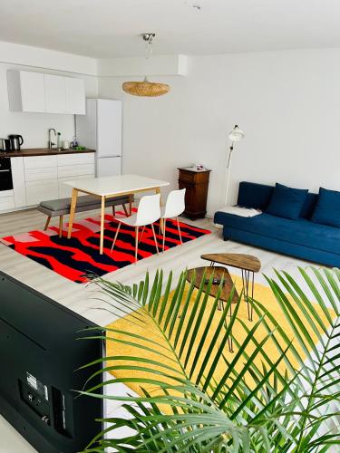 a living room with a table and a blue couch at Messewohnung Meerbusch Duesseldorf in Meerbusch