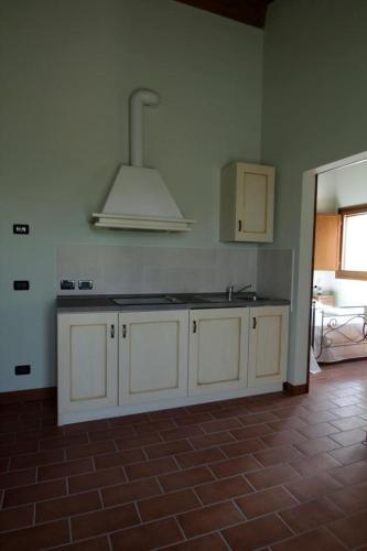 a kitchen with white cabinets and a sink at Corte Stellata Holiday Apartments in Stellata